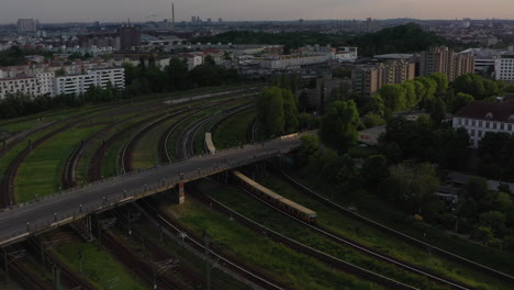 Tracking-of-S-bahn-train-unit-turning-on-tracks-into-station.-City-scene-lit-by-late-evening-sun.-Berlin,-Germany