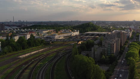 Fly-above-turning-multi-track-railway-line.-Revealing-train-station.-Aerial-view-of-transport-infrastructure-in-city-in-late-evening-sunshine.-Berlin,-Germany