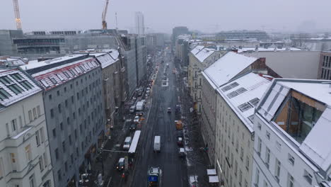 Forwards-fly-above-street-in-winter-city.--Queue-of-slowly-moving-cars-on-slippery-road.-Berlin,-Germany