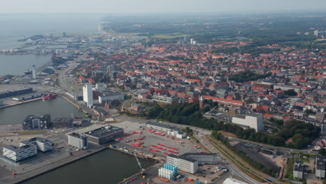 Stunning-skyline-aerial-view-of-Esbjerg,-one-of-the-most-important-seaport-in-Denmark.-Drone-view-moving-through-the-harbour-and-the-characteristic-beautiful-city-with-brick-buildings