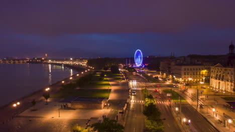 Night-Hyperlapse-of-Bordeaux,-France-Riverside-with-Ferris-Wheel,-Aerial-forward