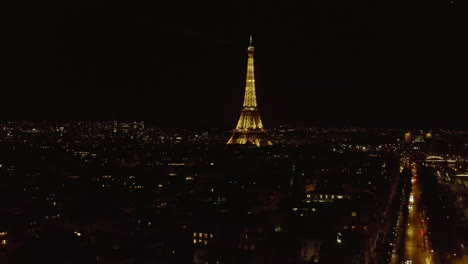 Eiffelturm-Bei-Nacht.-Fliegen-über-Die-Stadtentwicklung-Und-Blick-Auf-Das-Beleuchtete-Beliebte-Wahrzeichen-Im-Touristenziel.-Paris,-Frankreich