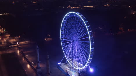 Empty-Ferris-Wheel-on-Plaza-at-Night-with-no-people-and-Blue-light-from-an-Aerial-Perspective