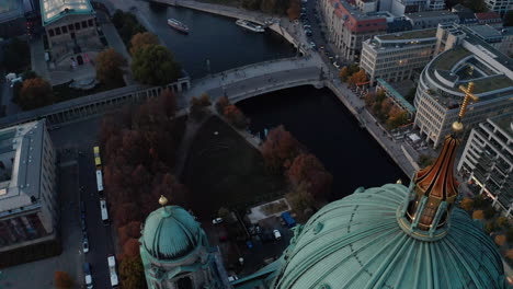 Flight-over-large-green-dome-of-Berlin-Cathedral.-Aerial-forwards-reveal-of-Spree-river-and-buildings-on-riverbanks.-Berlin,-Germany.