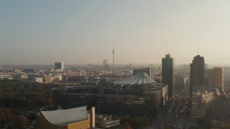 Forwards-fly-above-modern-urban-district,-area-around-Potsdamer-Platz.-Fernsehturm-TV-tower-in-distance.-Berlin,-Germany
