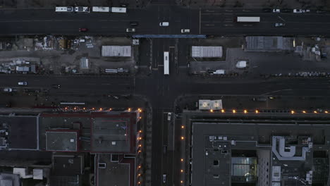 Aerial-birds-eye-overhead-top-down-view-of-traffic-on-wide-boulevard-at-twilight.-Construction-site-in-middle.-Berlin,-Germany