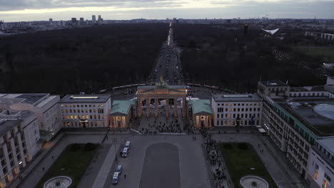 Aerial-footage-of-people-around-historic-Brandenburger-Tor-on-Under-den-Linden-street.-Well-known-landmark-at-dusk.-Berlin,-Germany