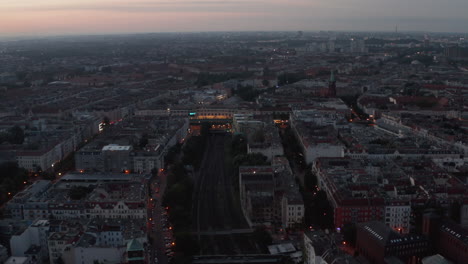 Slide-and-pan-aerial-view-of-morning-city.-Fly-above-urban-neighbourhood-before-sunrise.-Berlin,-Germany