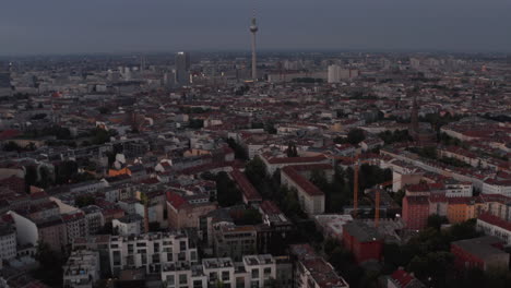 Tilt-up-reveal-of-cityscape-with-Fernsehturm-TV-tower.-Morning-fly-above-large-city.-Berlin,-Germany