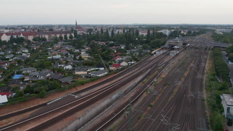 Tracking-of-Sbahn-train-driving-on-multitrack-railway-line.-Aerial-view-on-city-train.-Berlin,-Germany