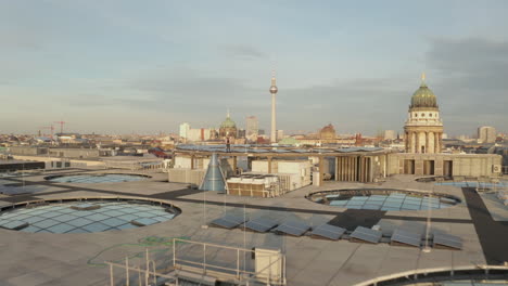 AERIAL:-Confident-young-man-standing-on-Rooftop-over-Berlin-Central,-Mitte-on-beautiful-sunny-day