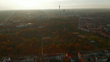 Beautiful-Stunning-Establishing-Shot-above-Berlin,-Germany-Skyline-Cityscape-in-colorful-Autumn-haze,-Slow-Aerial-tilt-up-Dolly-in
