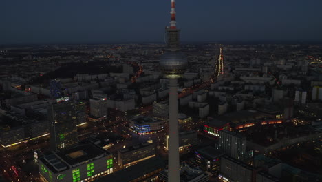 Rising-up-view-of-Berlin-Germany-TV-Tower-Alexanderplatz-at-Night-with-Cityscape-and-light-in-background,-Aerial-Drone-Crane-up-Shot