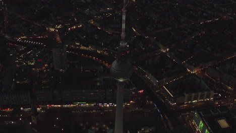 AERIAL:-Over-Berlin-Germany-TV-Tower-Alexanderplatz-at-Night-with-City-Lights-traffic