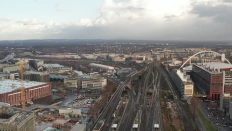Forwards-fly-above-railway-transport-infrastructure-in-suburb.-Crossing-of-railway-lines-with-multiple-bridges-over-busy-street.-Cologne,-Germany