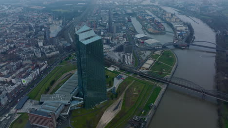 Elevated-shot-of-futuristic-European-Central-Bank-skyscraper.-bridge-over-river-in-city-and-harbour-in-background.-Frankfurt-am-Main,-Germany