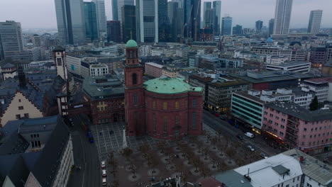 Old-brick-St.-Pauls-Church-on-Paulsplatz.-Tilt-up-reveal-of-cityscape-with-modern-downtown-skyscrapers.-Frankfurt-am-Main,-Germany