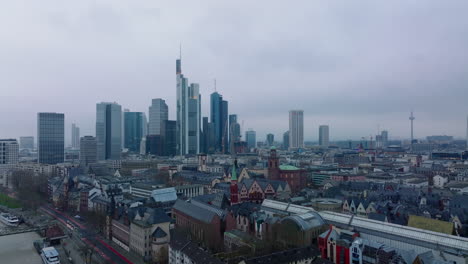 Fly-over-historic-city-centre.-Cityscape-with-group-of-modern-high-rise-office-buildings-on-cloudy-day.-Frankfurt-am-Main,-Germany