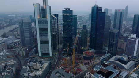 Aerial-ascending-footage-of-group-of-modern-downtown-skyscrapers-in-business-hub-at-twilight.-Frankfurt-am-Main,-Germany