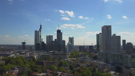 AERIAL:-Flying-towards-Beautiful-Frankfurt-am-Main-Skyline-with-Blue-Sky-and-Sun-Shining