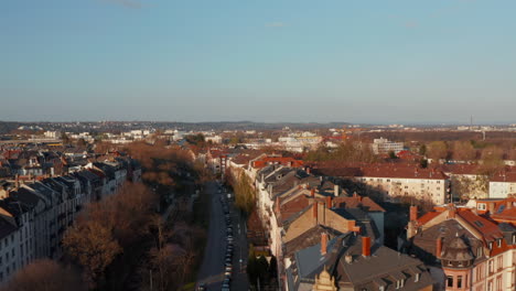 Aerial-view-of-city-neighbourhood.-Drone-following-wide-street.-Golden-hour.-Frankfurt-am-Main,-Germany