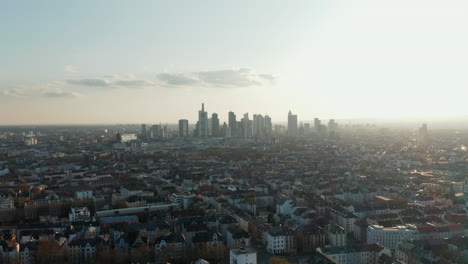Aerial-view-of-large-city-against-bright-sky-from-flying-drone.-Tracking-view-of-cityscape-with-skyscrapers-downtown.-Skyline-of-business-centre.-Frankfurt-am-Main,-Germany
