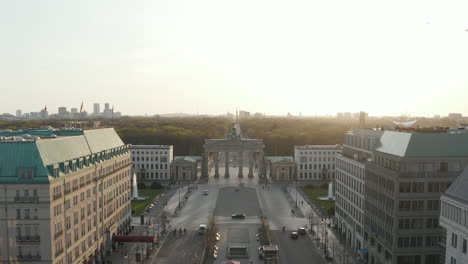 AERIAL:-Brandenburger-Tor-with-almost-no-People-in-Berlin,-Germany-due-to-Coronavirus-COVID-19-Pandemic-in-Beautiful-Sunset-Light