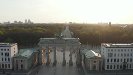 AERIAL:-Over-Brandenburger-Tor-with-almost-no-People-in-Berlin,-Germany-due-to-Coronavirus-COVID-19-Pandemic-in-Beautiful-Sunset-Light