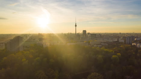 Scenic-Hyper-Lapse-fast-moving-Time-Lapse-above-Cityscape-with-Nature-and-Skyline,-Berlin-Germany-TV-Tower-in-golden-hour-sunset-light,-Aerial-Establishing-Shot
