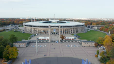Cars-parked-in-front-of-Olympia-Stadium-in-Berlin,-Germany,-Aerial-Wide-view-Dolly-backwards-establishing-shot,-October-2020