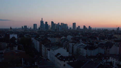 Aerial-drone-view-of-large-city-against-colourful-sunset-sky.-Group-of-skyscrapers-downtown.-Skyline-of-business-and-financial-centre.-Frankfurt-am-Main,-Germany