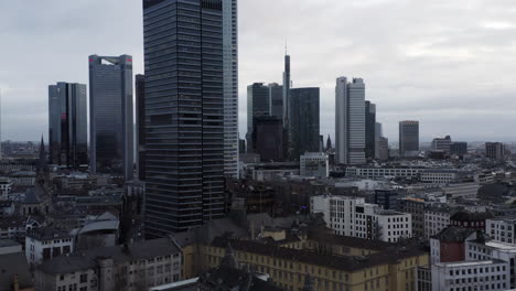 Forwards-fly-above-urban-neighbourhood.-View-of-modern-high-rise-business-buildings-against-cloudy-sky.-Frankfurt-am-Main,-Germany