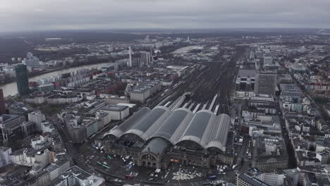 AERIAL:-Epic-View-over-Frankfurt-am-Main-Central-Train-Station-on-Cloudy-Grey-Winter-Day