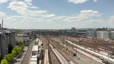 AERIAL:-Forward-Flight-over-Frankfurt-am-Main,-Germany-Central-Train-Station-Train-Tracks-on-beautiful-Summer-Day-with-little-Traffic-due-to-Coronavirus-Covid-19-Pandemic