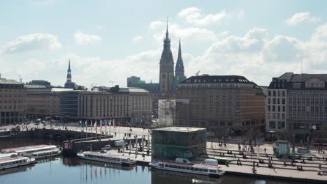 Aerial-view-of-people-on-the-street-by-Binnenalster-lake-with-Hamburg-city-hall-in-the-background
