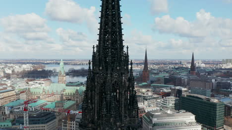 Aerial-close-up-view-of-dark-charred-spire-of-St.-Nikolai-world-war-Memorial-and-former-church-ruins-in-Hamburg,-Germany