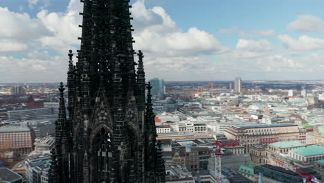 Close-up-aerial-orbit-of-dark-church-spire-of-St.-Nikolai-world-war-Memorial-and-Museum-in-Hamburg,-Germany