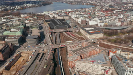 Aerial-view-of-two-trains-arriving-into-Hamburg-main-train-station-under-road-overpass