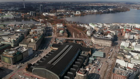 Aerial-view-of-multiple-train-tracks-and-train-arriving-at-Hamburg-main-train-station-by-Binnenalster-lake