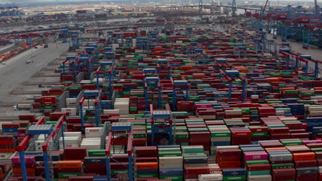 Aerial-view-of-multiple-automated-industrial-cranes-moving-large-cargo-containers-in-Hamburg-port