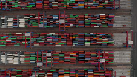 Overhead-top-down-aerial-view-of-automated-cranes-moving-colorful-cargo-containers-in-Hamburg-port