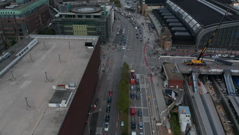 Forwards-fly-above-busy-street-around-Hamburg-Hauptbahnhof.-Tilt-up-reveal-of-urban-neighbourhood-with-transport-infrastructure.-Free-and-Hanseatic-City-of-Hamburg,-Germany