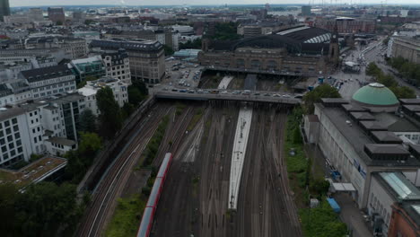 Forwards-tracking-view-of-train-arriving-into-Hamburg-Hauptbahnhof-train-station.-Aerial-shot-of-railway-tracks-and-historical-building.-Free-and-Hanseatic-City-of-Hamburg,-Germany