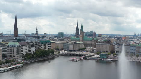 Aerial-view-of-historic-city-centre-on-Binnenalster-lake-waterfront.-Several-tall-towers-of-city-hall-and-churches.-Free-and-Hanseatic-City-of-Hamburg,-Germany