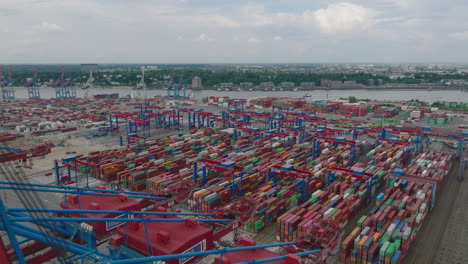 Forwards-fly-above-logistic-terminal.-Rows-of-colourful-stacked-naval-containers-and-large-cranes.-Intermodal-transport-and-global-logistics.-Hamburg,-Germany