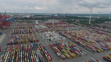 Aerial-footage-of-vast-logistic-site-with-stacked-naval-cargo-containers.-Transport-terminal-in-harbour-in-city.-Hamburg,-Germany