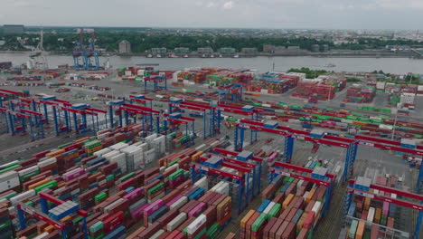 Aerial-view-of-traffic-in-logistic-terminal.-Forwards-fly-above-rows-of-containers-and-moving-cranes-and-vehicles.-Intermodal-transport-and-global-logistics.-Hamburg,-Germany