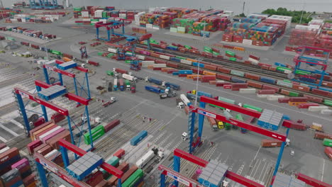 High-angle-view-of-work-in-transport-terminal.-Cranes-in-harbour-moving-with-containers-from-various-vehicles.-Intermodal-transport-and-global-logistics.-Hamburg,-Germany