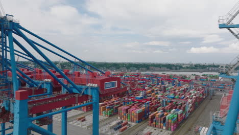 Fly-around-large-gantry-cranes-in-harbour.-Revealing-logistic-terminal-with-rows-of-naval-containers.-Intermodal-transport-and-global-logistics.-Hamburg,-Germany