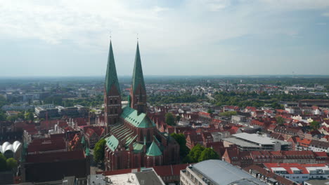 Aerial-view-of-old-town.-Orbiting-around-Marienkirche,-main-parish-church.-Brick-gothic-religious-building.-Luebeck,-Schleswig-Holstein,-Germany